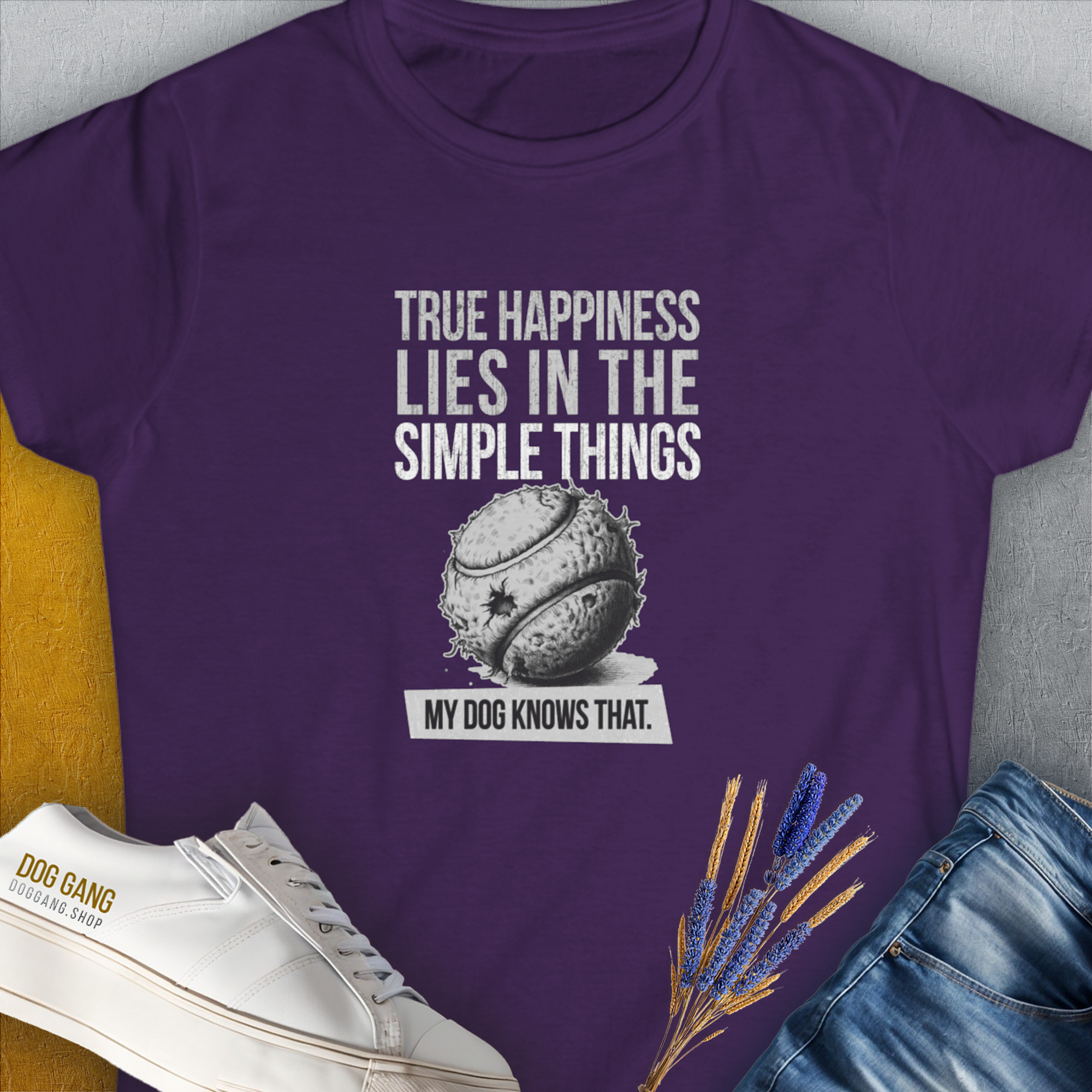 Purple tee features True happiness lies in the simple things, my dog knows that, showing a simple tennis ball. Perfect for any dog lover. Designed by Dog Gang.