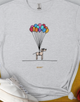 Dog lover gift: A cartoon dog floats with colorful balloons on the minimalistic tee. Designed by Dog Gang.