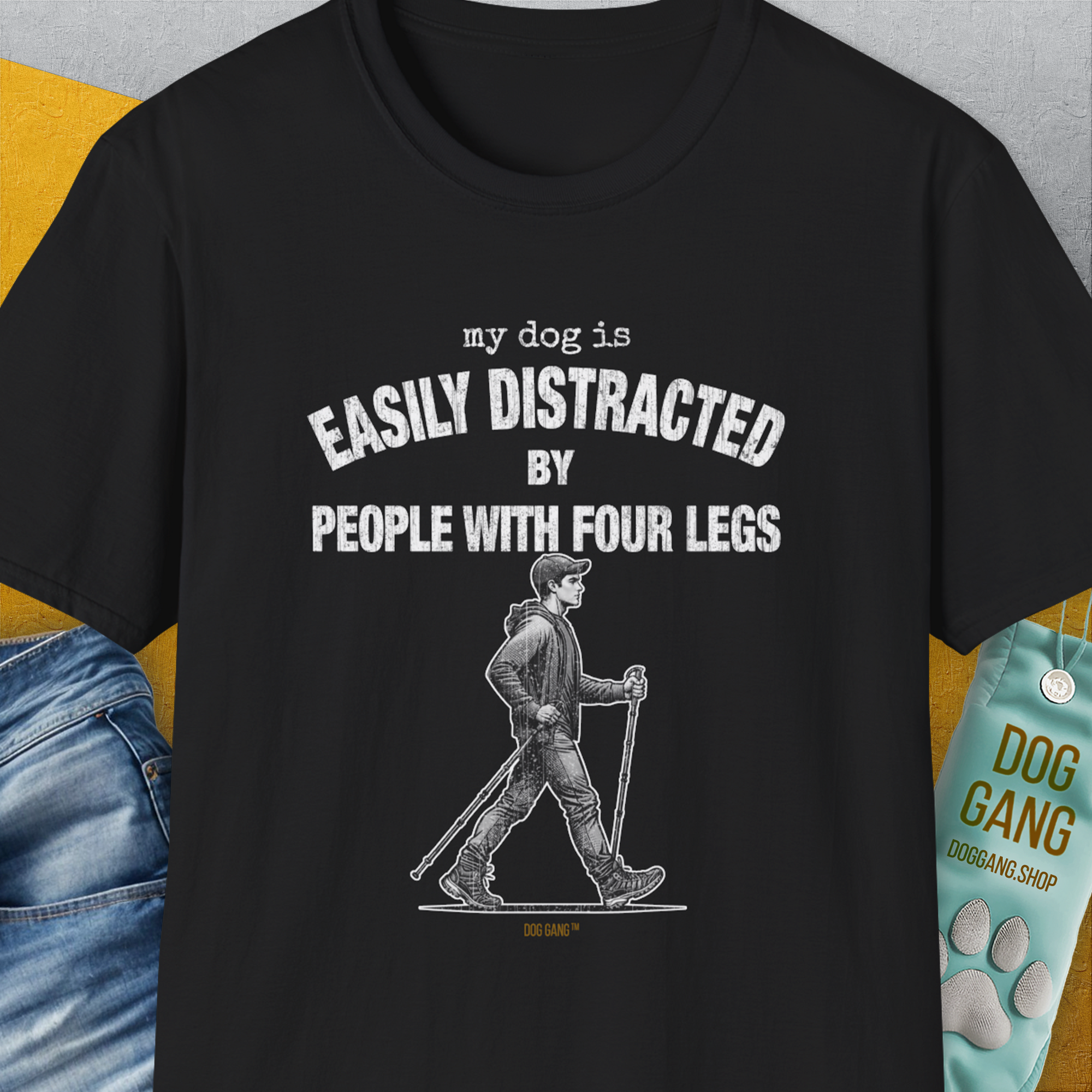 The black T-shirt features a funny quote: My Dog Is Easily Distracted By - Volume 5: People With Four Legs, with a cartoon of someone walking with walking sticks. Designed by Dog Gang.