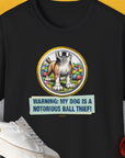 Funny dog shirt: Warning: My Dog Is A Notorious Ball Thief, Volume 2 with a playful illustration of a mischievous dog and colorful balls. Designed by Dog Gang.