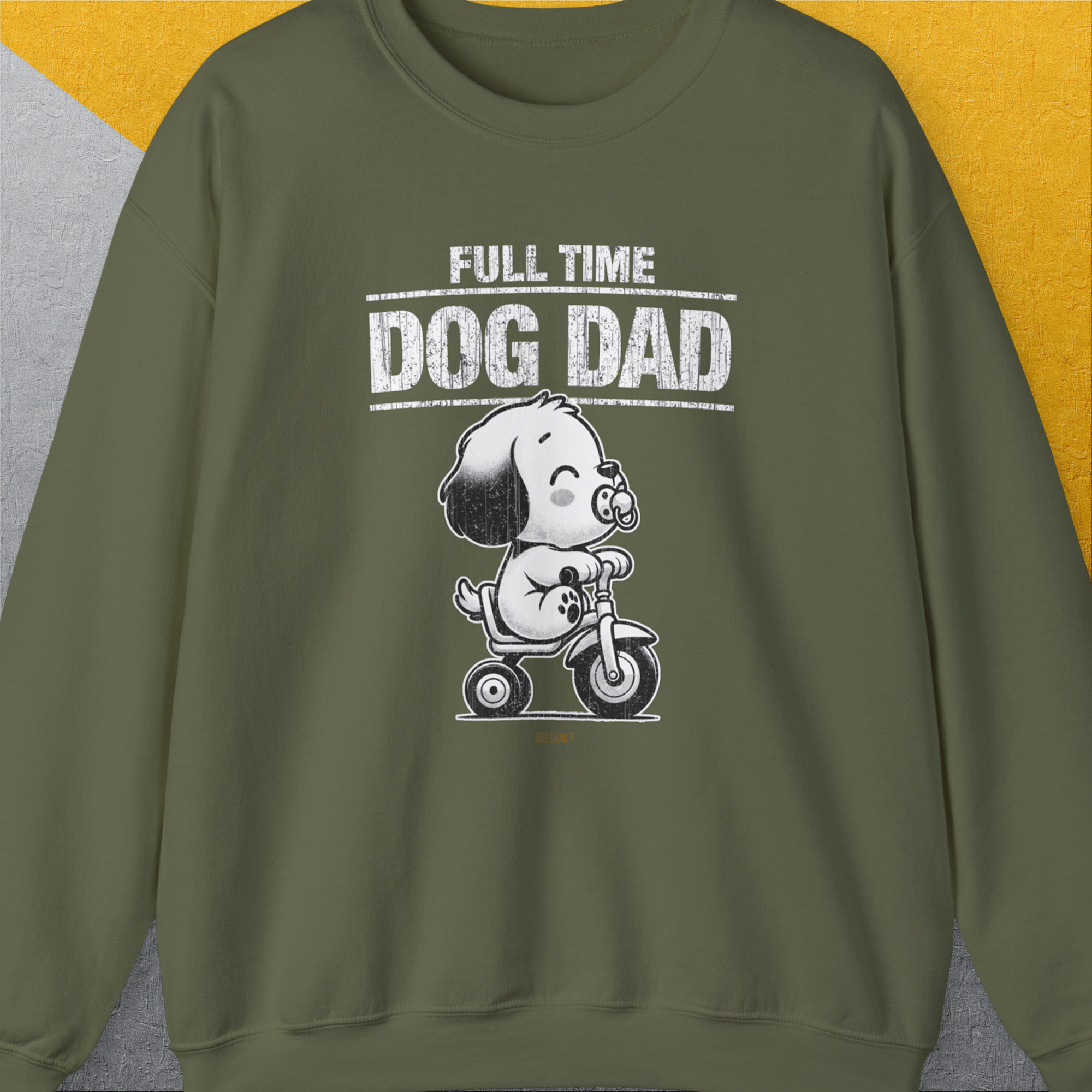 Unisex Sweatshirt in Military Green features a cartoon dog on a tricycle with the text Full Time Dog Dad on gray and yellow. Perfect for any dog lover. Designed by Dog Gang.