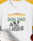 Certified “Dog Dad” text featuring a very cute cartoon puppy, a baby milk bottle and a stuffed mouse toy. Designed by Dog Gang.