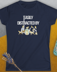 The Easily Distracted By Dogs womens tee, Volume 1, in navy blue showcases a playful dog-themed design with charming dog imagery incorporated within the word Dogs in white. Made from ringspun cotton for a semi-fitted feel. Designed by Dog Gang.
