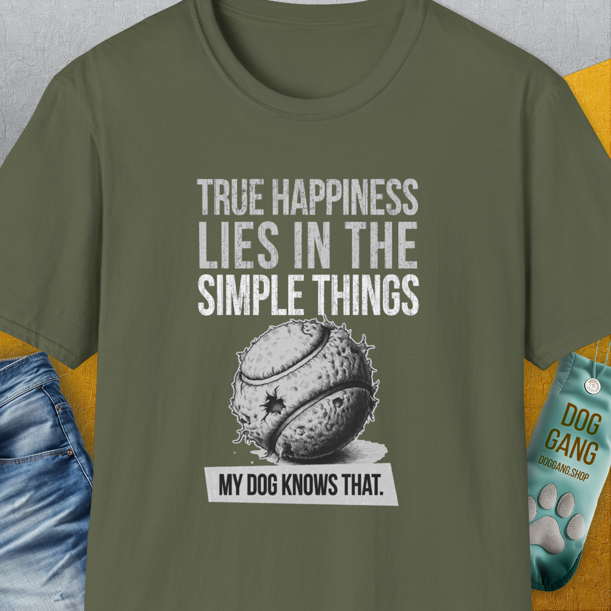 Military green tee with a torn and chewed ball ball graphic and quote: True happiness lies in the simple things. My dog knows that. A perfect funny dog shirt for any dog person. Designed by Dog Gang.