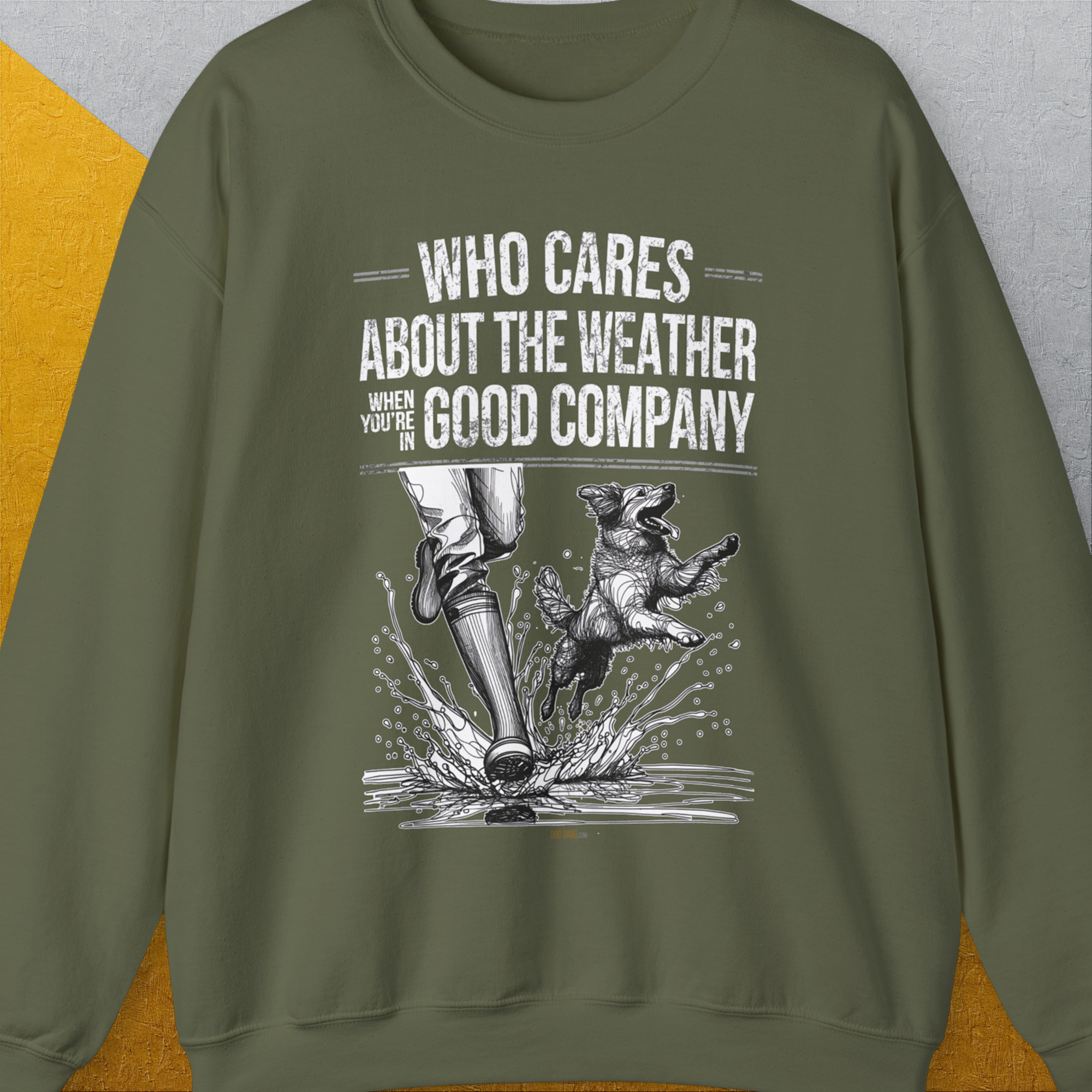 The unisex sweatshirt, Who Cares About The Weather When Youre In Good Company, Volume 1, features a playful slogan and design with a dog jumping beside human legs in boots. Made from an ethically sourced US cotton-polyester blend, it ensures both comfort and responsible sourcing.
