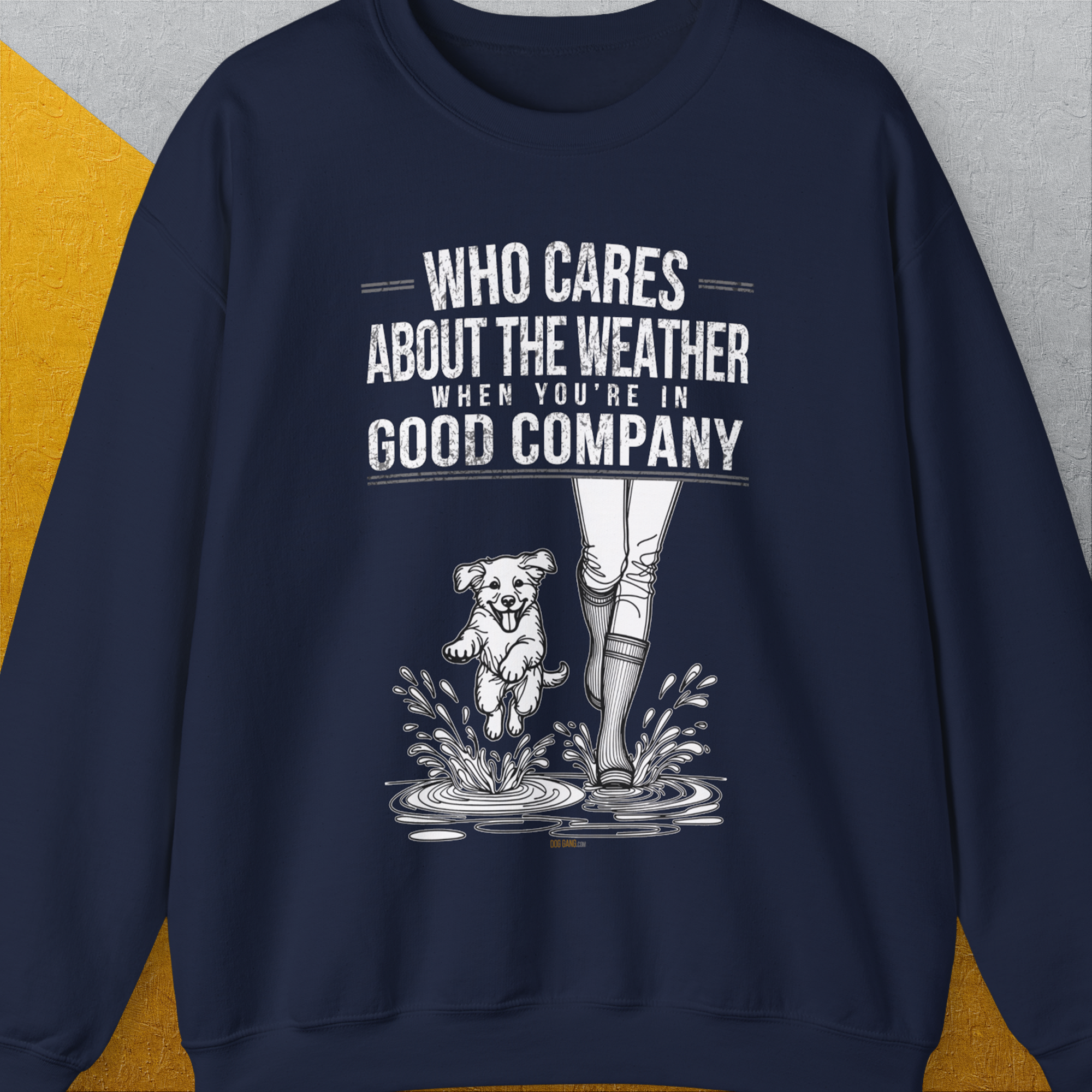USA navy sweatshirt with a playful dog splashing in boots, featuring the saying Who Cares About The Weather When Youre In Good Company, Volume 2. Perfect for any dog lover. Designed by Dog Gang.