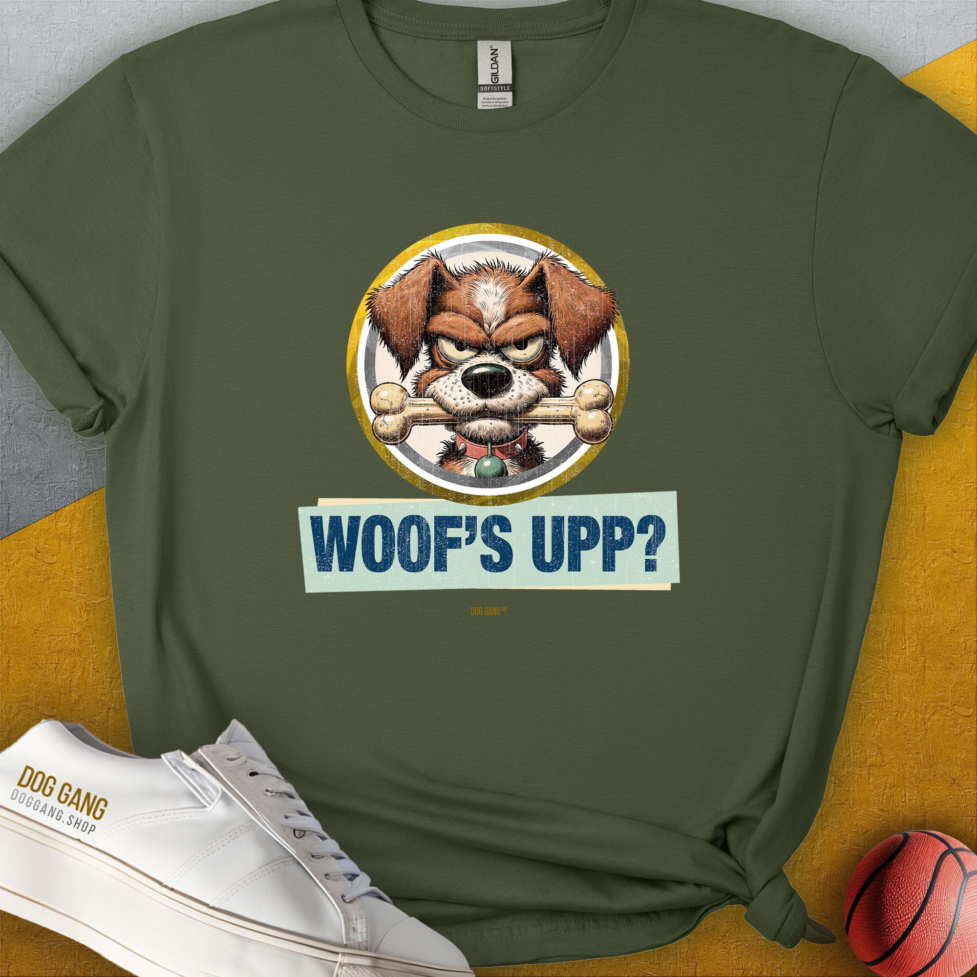 The Woofs Upp? Volume 2 T-shirt is a funny dog shirt with a cartoon dog holding a bone in his mouth, saying "WOOFS UPP?" Perfect for the dog lover. Designed by Dog Gang.