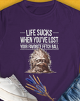 This womens purple tee features a cute dog design with the quote Life sucks when youve lost your favorite fetch ball. A perfect gift for any dog lover. Designed by Dog Gang.