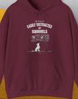 The shirt features a funny dog and squirrel graphic with the quote "My dog is easily distracted by squirrels." Designed by Dog Gang.