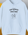 The funny dog shirt shows a simple line drawing of a dog with the words my dog is easily distracted by love & hugs. Designed by Dog Gang.