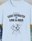 The My Dog Is Easily Distracted By - Volume 3: Love And Hugs unisex tee showcases a cute dog illustration with text, perfect for any dog lover. Designed by Dog Gang.