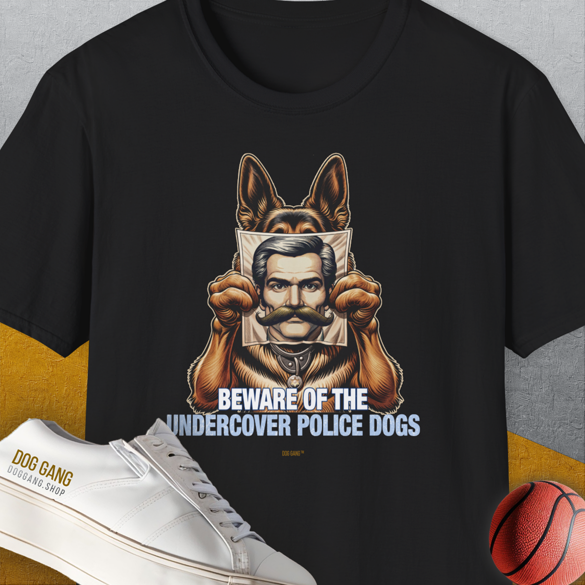 Unisex black cotton T-shirt featuring a cartoon German Shepherd police dog holding a mans picture. Text reads: "BEWARE OF THE UNDERCOVER POLICE DOGS". Funny dog shirt. Designed by Dog Gang.