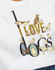 A person wears the I Love Dogs - Series I, Volume 1 unisex T-shirt in white, showcasing a beautiful design of black and gold text creatively intertwined with various dog breed illustrations. Made from 100% cotton for soft comfort. Designed by Dog Gang.
