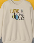 Sand-colored unisex sweatshirt with I LOVE dOGS and a graphic of a woman walking dogs. Made from ethically grown US cotton. Designed by Dog Gang.