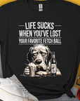 Life Sucks When Youve Lost Your Favorite Fetch Ball, Volume 5 unisex t-shirt. Funny drawing od a depressed dog's face. Next to the dog is a full glass and a bottle with a label that says: "Chicken Soup with whipped cream, for sad dog days". Designed by Dog Gang.