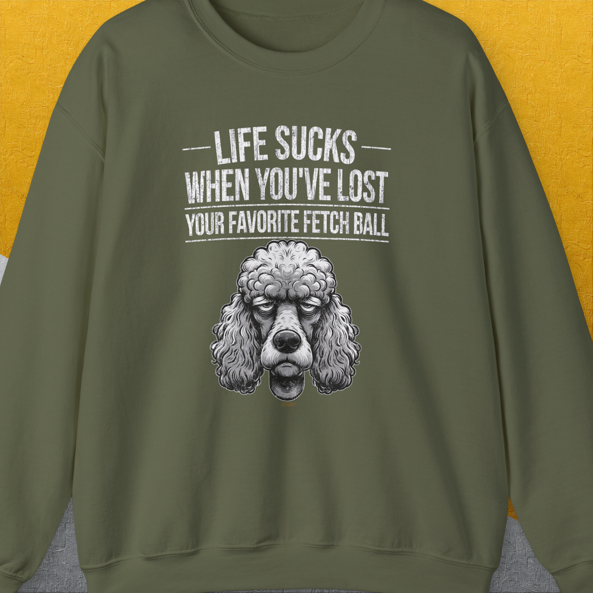 The military green sweatshirt showcases a cute poodle illustration with the funny saying, Life Sucks When Youve Lost Your Favorite Fetch Ball, Volume 7. Designed by Dog Gang.