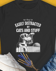 Black tee with a cute dog cartoon, featuring the phrase Easily Distracted by Cats and Stuff. Perfect for any dog person or funny dog shirt enthusiast. Designed by Dog Gang.