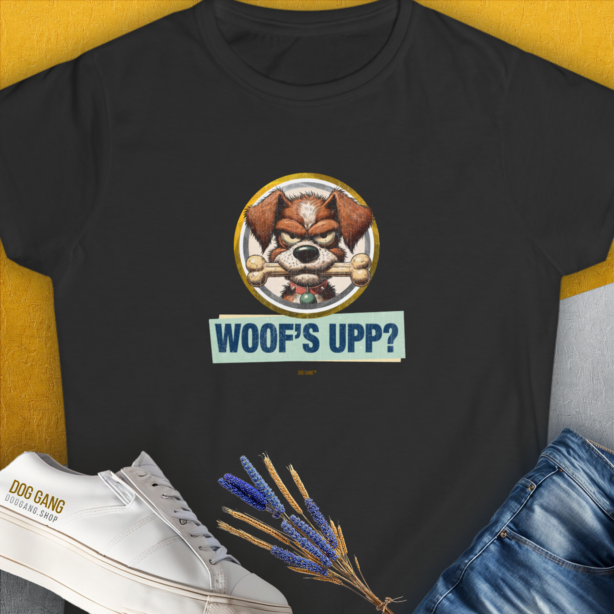 The shirt features a cute cartoon dog with the words Woofs Upp? in playful text. Funny dog design for any casual day. Designed by Dog Gang.